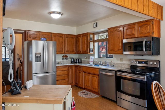 11 N County Road N1030 St, Greer, AZ 85927 - kitchen with appliances with stainless steel finishes, a sink, light wood-style floors, and brown cabinets