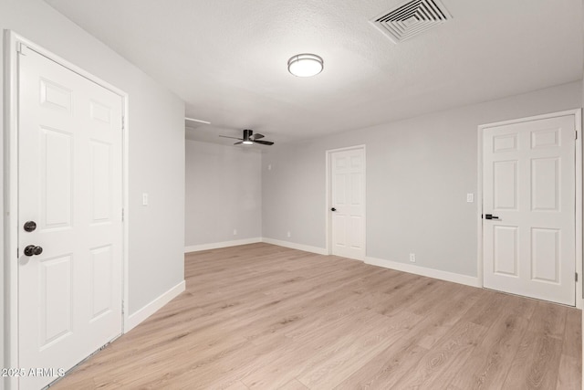 unfurnished room with light wood-type flooring, ceiling fan, and a textured ceiling