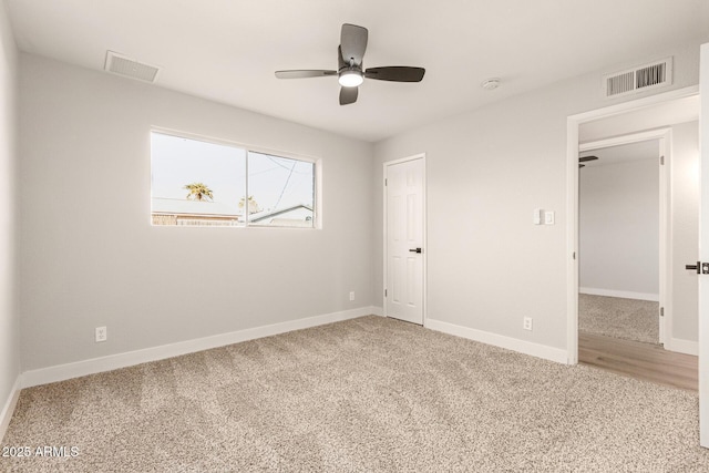 carpeted spare room with ceiling fan