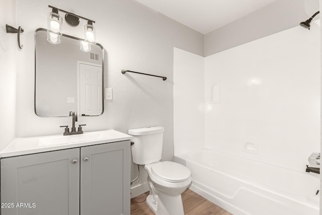 full bathroom with tub / shower combination, hardwood / wood-style floors, toilet, and vanity