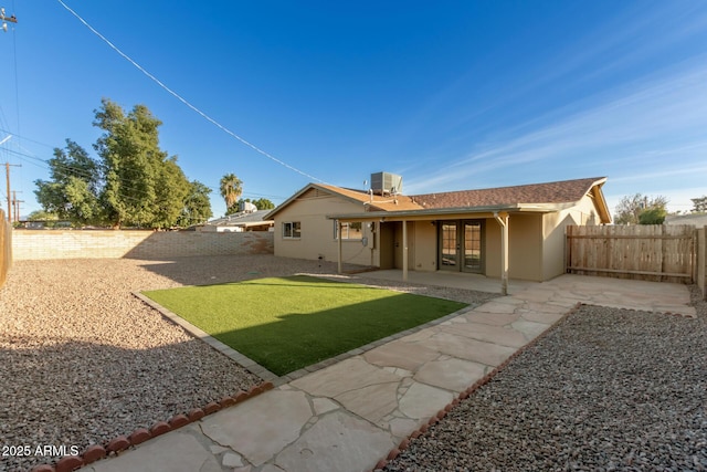 back of house with a lawn, central air condition unit, a patio, and french doors