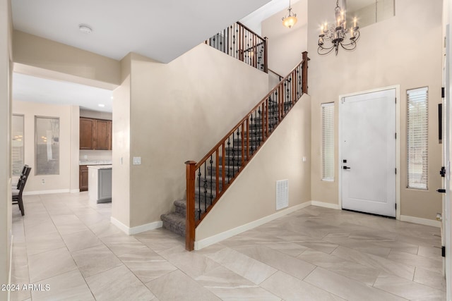 foyer featuring a towering ceiling and a chandelier