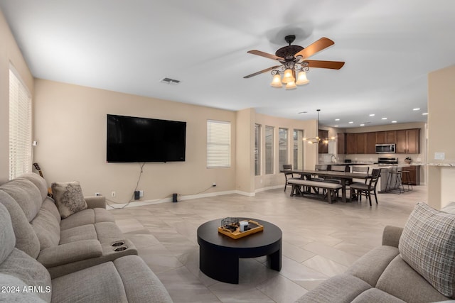 living room with ceiling fan with notable chandelier and light tile patterned floors