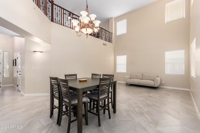 dining space featuring a high ceiling and an inviting chandelier