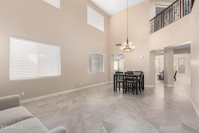 dining space featuring a high ceiling and a notable chandelier