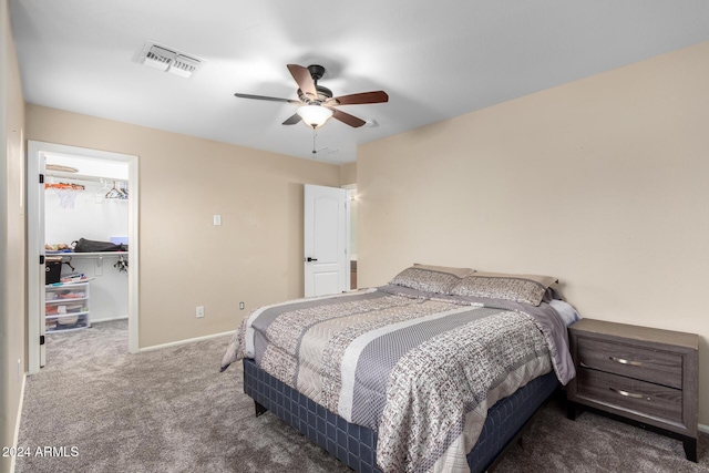 bedroom with dark colored carpet, a spacious closet, a closet, and ceiling fan