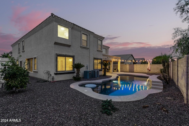 pool at dusk featuring central AC and a patio area