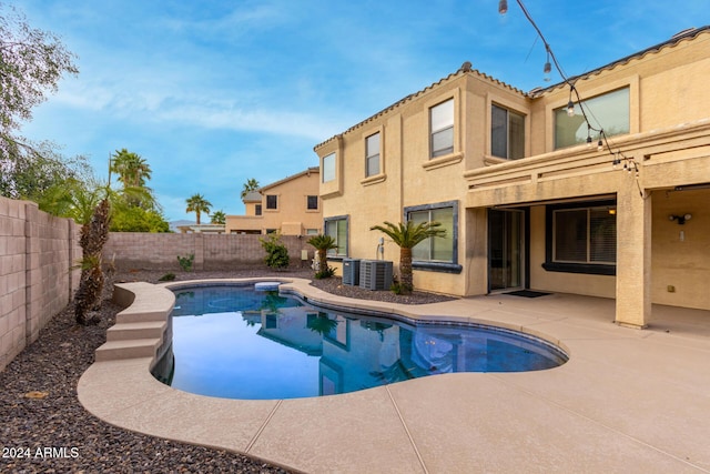 view of swimming pool featuring central air condition unit and a patio