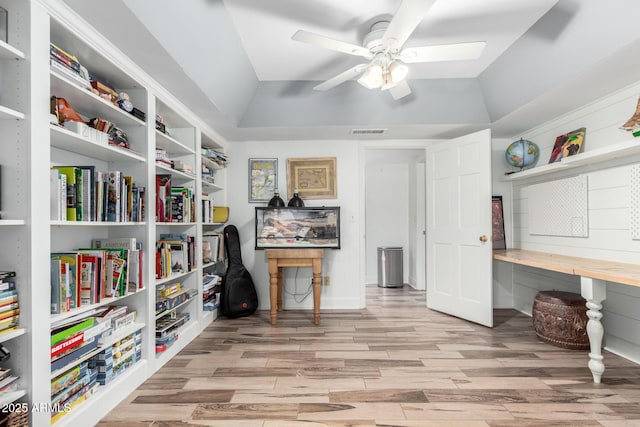 office area featuring light wood-style floors, lofted ceiling, visible vents, and ceiling fan