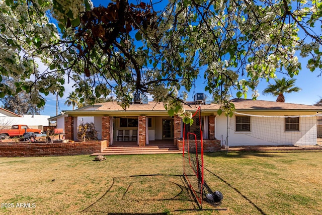 rear view of house with brick siding and a lawn