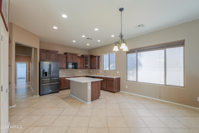 kitchen with a center island, hanging light fixtures, stainless steel fridge, light tile patterned floors, and a chandelier