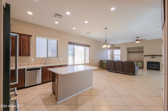 kitchen with dishwasher, light tile patterned flooring, ceiling fan with notable chandelier, dark brown cabinetry, and a center island