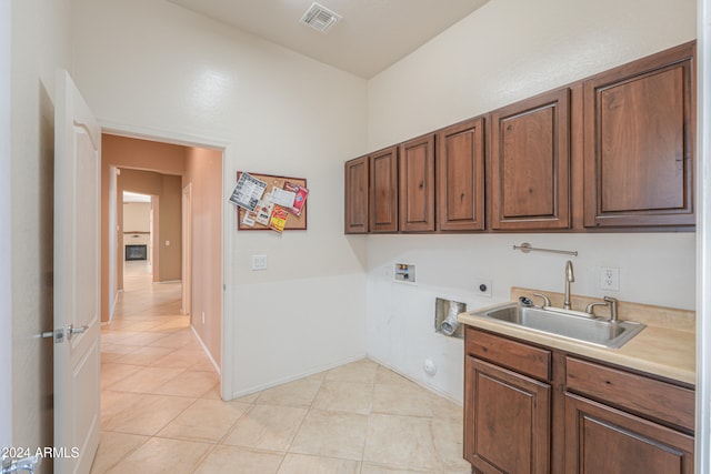 clothes washing area with cabinets, hookup for a washing machine, light tile patterned flooring, hookup for an electric dryer, and sink