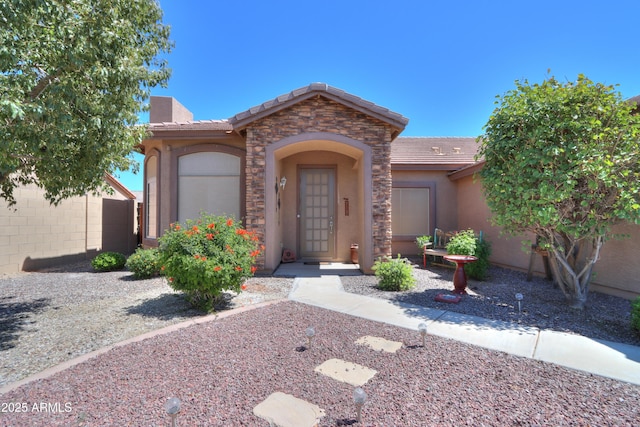 view of front of home featuring stucco siding, stone siding, and a tiled roof