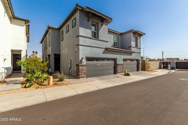 1829 N 43rd Ter, Phoenix, AZ 85008 - view of front of house featuring a garage, stucco siding, concrete driveway, and stone siding
