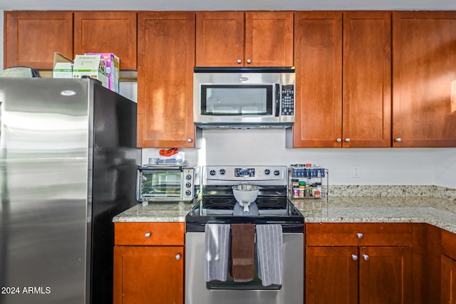 kitchen featuring light stone countertops and stainless steel appliances