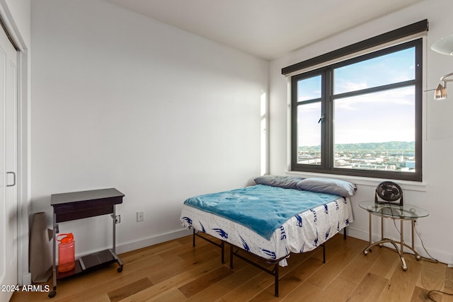 bedroom featuring a mountain view and light wood-type flooring