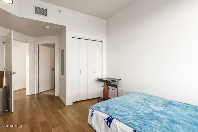 bedroom with light hardwood / wood-style flooring and a closet