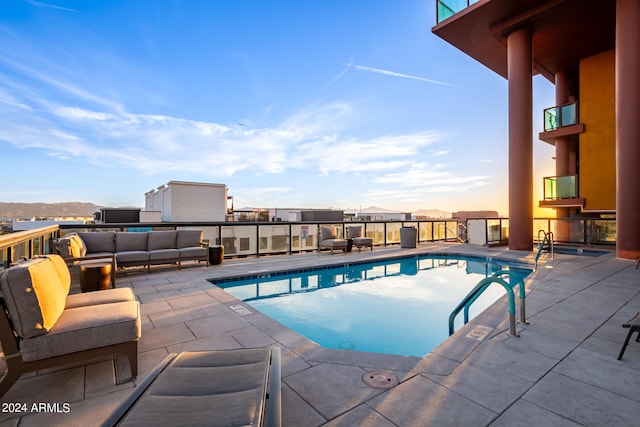 view of swimming pool with a patio, a mountain view, and outdoor lounge area