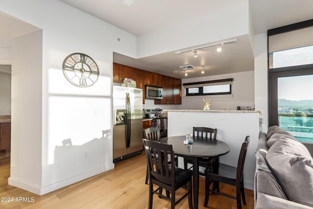 dining room with track lighting and light wood-type flooring