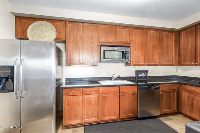 kitchen featuring light tile patterned floors, appliances with stainless steel finishes, and sink