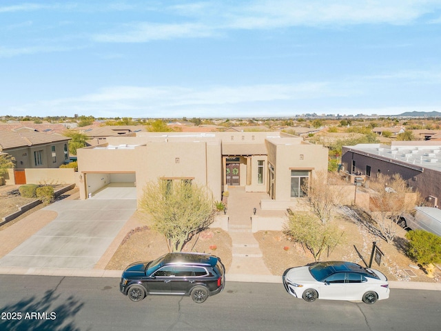 pueblo-style house featuring a garage