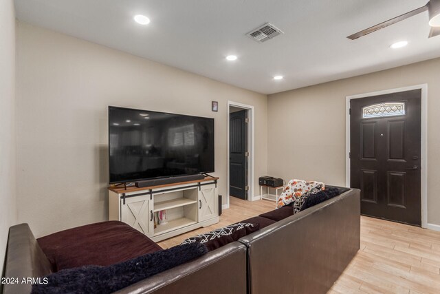 living room featuring ceiling fan and light wood-type flooring