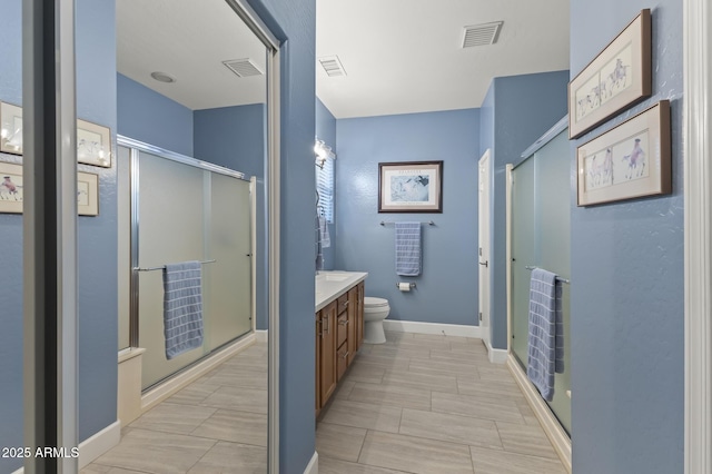 bathroom with vanity, toilet, and a shower with shower door