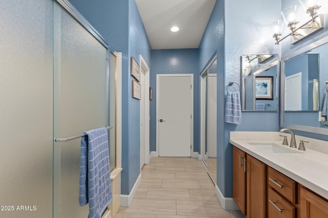 bathroom featuring walk in shower and vanity