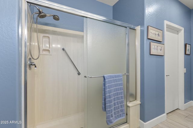 bathroom featuring hardwood / wood-style flooring and a shower with door