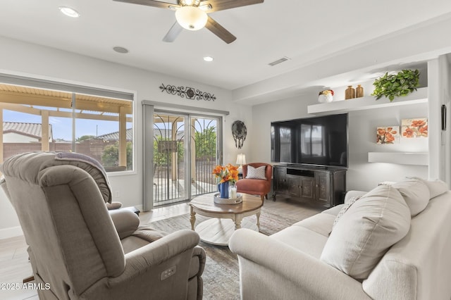 living room with ceiling fan and light wood-type flooring