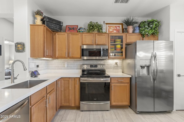 kitchen with tasteful backsplash, appliances with stainless steel finishes, and sink