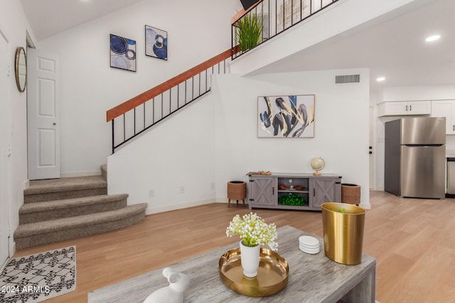 living room with light hardwood / wood-style flooring and vaulted ceiling