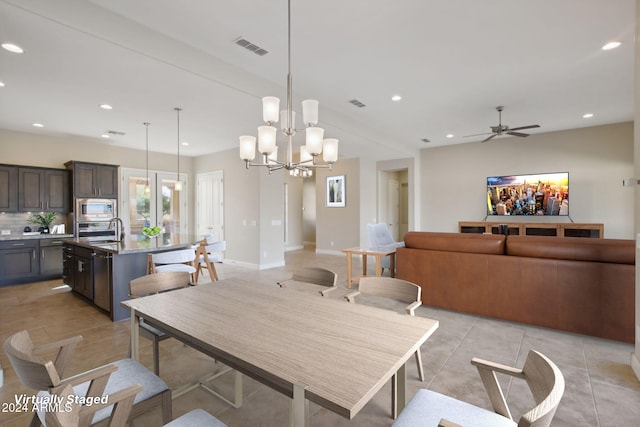 dining area with sink, light tile patterned floors, and ceiling fan with notable chandelier