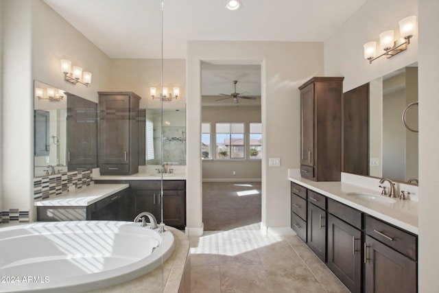 bathroom with tile patterned floors, tiled tub, ceiling fan, and vanity