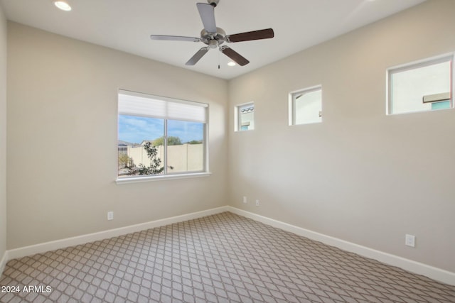 empty room featuring ceiling fan, plenty of natural light, and carpet