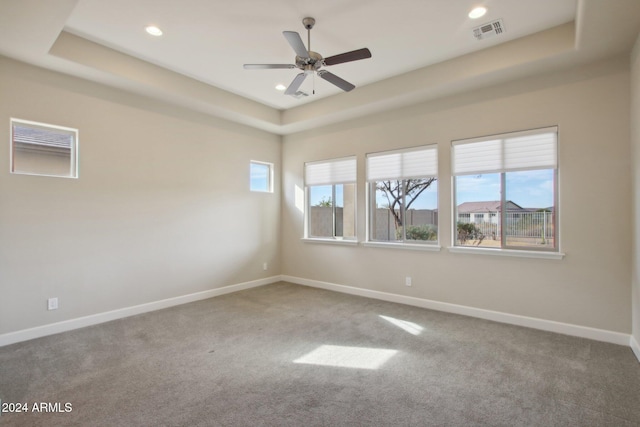 carpeted empty room featuring ceiling fan and a tray ceiling