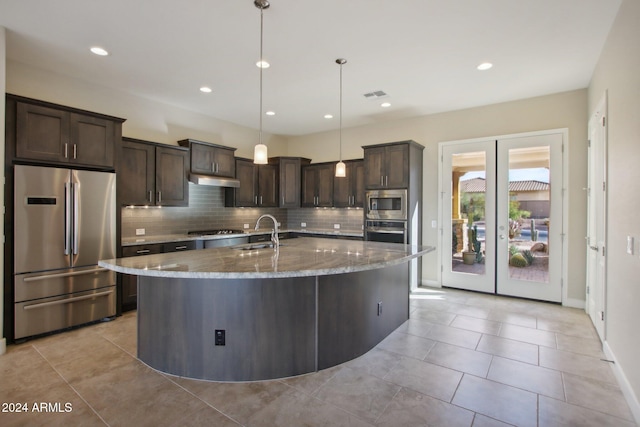 kitchen featuring pendant lighting, french doors, sink, appliances with stainless steel finishes, and light stone counters