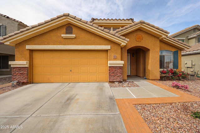mediterranean / spanish-style house featuring concrete driveway, a tiled roof, an attached garage, and stucco siding