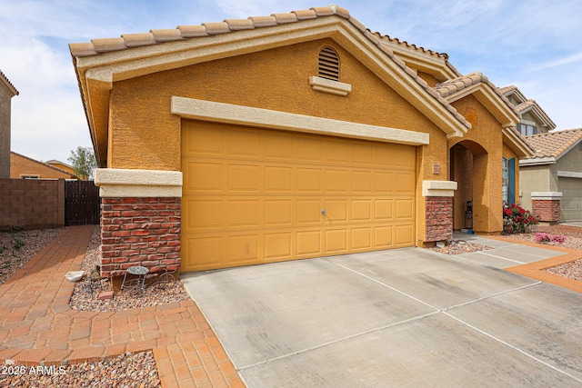 view of front of home with fence, an attached garage, driveway, and stucco siding