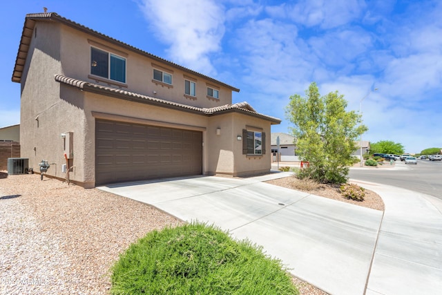 view of front of home with central AC and a garage