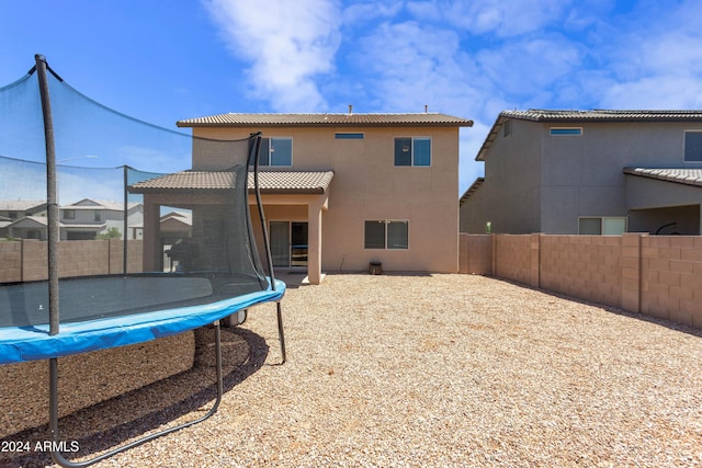 rear view of house with a trampoline