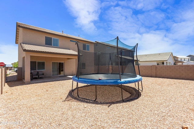 rear view of property featuring a trampoline