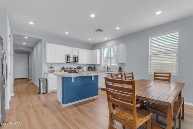 724 S 11th St, Coolidge, AZ 85128 - kitchen with stainless steel appliances, a center island, white cabinetry, light wood-style flooring, and recessed lighting