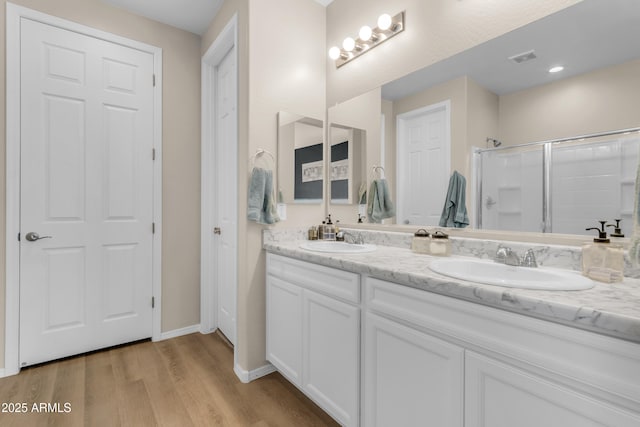 724 S 11th St, Coolidge, AZ 85128 - bathroom with double vanity, a shower with door, and wood finished floors