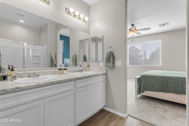724 S 11th St, Coolidge, AZ 85128 - ensuite bathroom featuring double vanity, wood finished floors, a shower with shower door, and ceiling fan