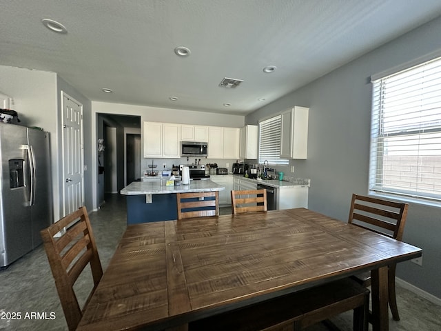 724 S 11th St, Coolidge, AZ 85128 - kitchen with appliances with stainless steel finishes, white cabinets, a kitchen island with sink, recessed lighting, and light stone countertops