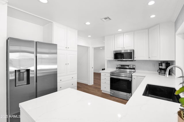 2607 E Mercer Ln, Phoenix, AZ 85028 - kitchen featuring appliances with stainless steel finishes, recessed lighting, white cabinetry, dark wood-style floors, and light stone counters