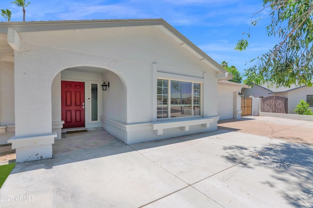 2607 E Mercer Ln, Phoenix, AZ 85028 - view of front facade featuring a gate, concrete driveway, stucco siding, and a garage