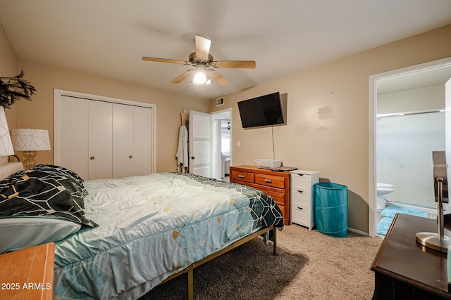 carpeted bedroom with a closet, ensuite bath, and ceiling fan